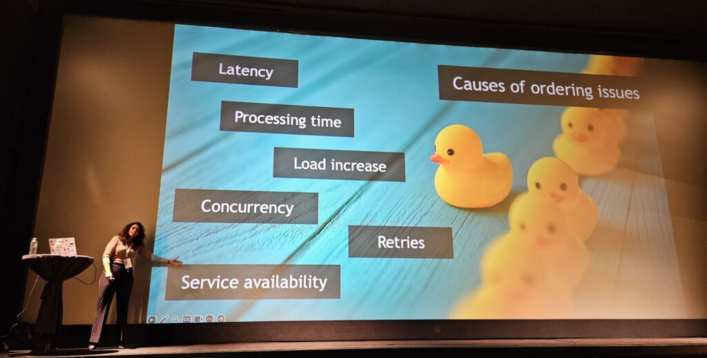 Slide with Leila Bougria standing in front listing Causes of ordering issues: Latency, Processing time, Load increase, Concurrency, Retires, Service availability